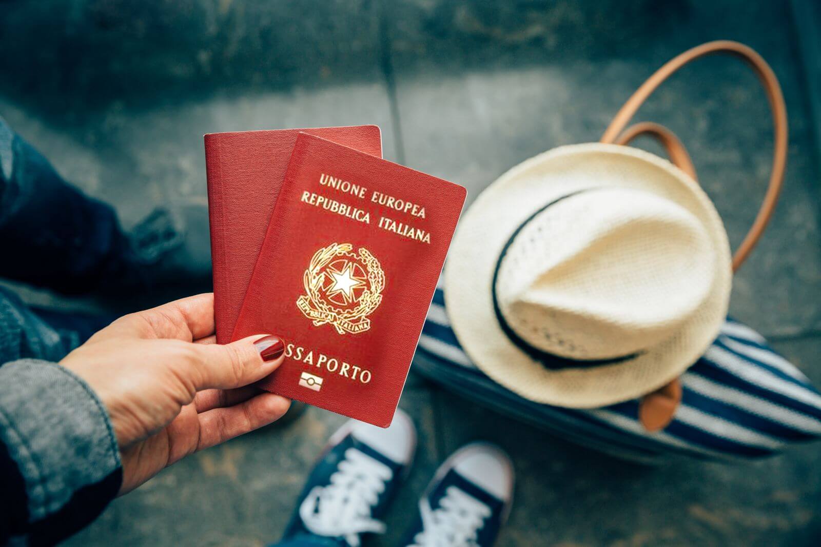 passaportes italianos mao unhas vermelhas bolsa listrada chapeu bege
