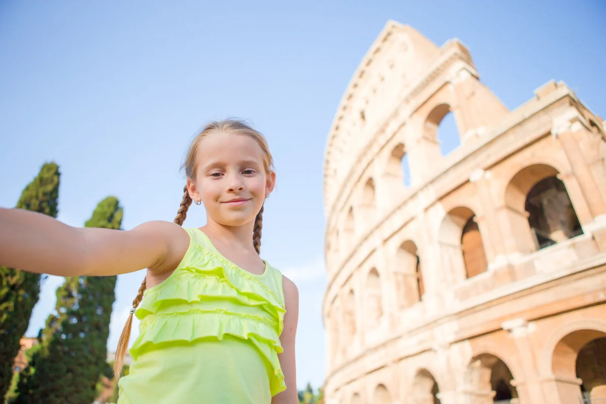 Criança fazendo selfie com o Coliseu ao fundo em Roma