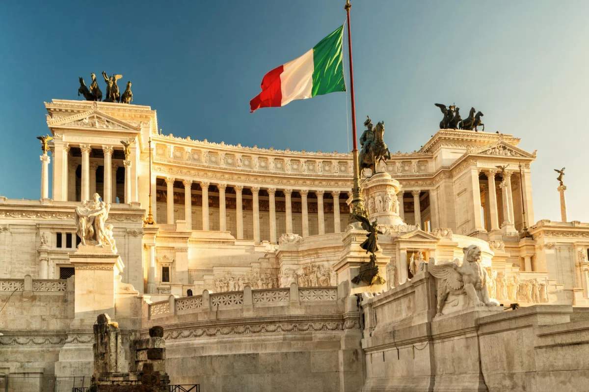 Monumento a Vittorio Emanuele II em Roma com bandeira italiana ao vento e céu azul